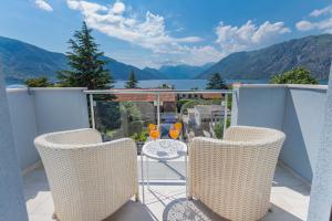 a balcony with chairs and a table with two glasses at Apartments Stetonn in Kotor