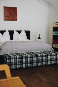 a bedroom with a bed with a plaid blanket at Heurigenhof Bründlmayer in Langenlois