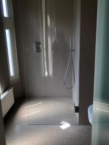 a person taking a picture of a shower in a bathroom at The Scent Residence in Antwerp