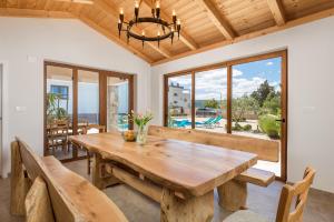a dining room with a wooden table and benches at Villa Grandioza in Seline