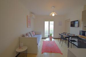 a living room with a couch and a table at Casa Flamingo - Appartement charmant et moderne - 6 - in Canet-en-Roussillon