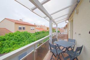 a patio with a table and chairs on a balcony at Casa Flamingo - Appartement charmant et moderne - 6 - in Canet-en-Roussillon