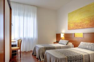 a hotel room with two beds and a table at Euro Hotel in Nuoro +50 photos