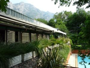 リモーネ・スル・ガルダにあるHotel Lidoのスイミングプールと植物が目の前にある家