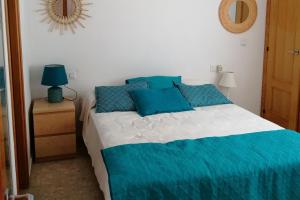 a bedroom with a bed with blue pillows and a mirror at Sector 5 Napols AP844 in Oliva +25 photos