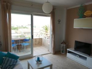 a living room with a television and a balcony at Sector 5 Napols AP844 in Oliva