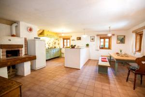 eine Küche mit weißen Geräten und einem Tisch darin in der Unterkunft Wild flower cottage in Trenta in Trenta