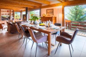 a dining room with a wooden table and chairs at Chalet Musini - OVO Network in Le Grand-Bornand