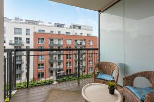 balkon ze stołem i krzesłami oraz budynek w obiekcie Grand Apartments - Szafuza Apartment Gdańsk Szafarnia w Gdańsku