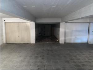 an empty room with two garage doors and a tile floor at Knokke luxury appartement in Knokke-Heist