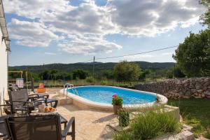 una piscina en un patio con mesa y sillas en Holiday Home Sego with Private Pool, en Veliki Broćanac