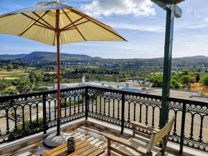 a patio with an umbrella and two chairs on a balcony at Katouni Bridge Villa in Kythira