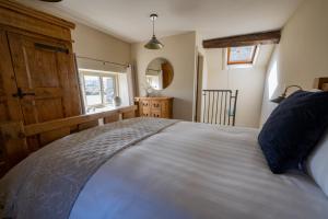 Un dormitorio con una cama grande y una ventana en Thornes Cottage, en Huddersfield