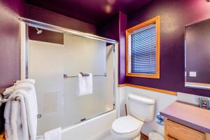 a purple bathroom with a toilet and a shower at Spacious Seaside Home with an Ocean View in Seaside