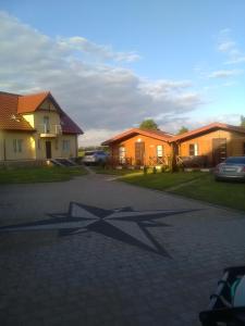 a shadow of a star on the ground in front of houses at Domki 50m od nowej plaży i promenady w Mikolajkach in Mikołajki
