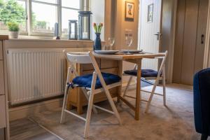 a dining room table with two chairs and a table at Thornes Cottage in Huddersfield
