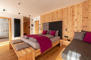 a bedroom with a large bed with wooden walls at Garnì Lilly in San Lorenzo in Banale
