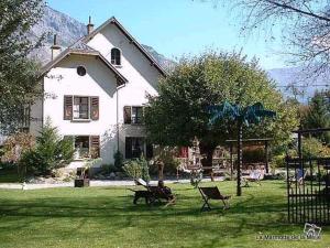 a house with a yard with chairs in the grass at La Marmotte De La Meije in Le Bourg-dʼOisans
