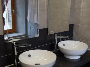 a bathroom with a white sink and a mirror at La Marmotte De La Meije in Le Bourg-dʼOisans