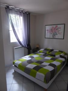 - une chambre avec un lit et une couverture en damier dans l'établissement Villa avec piscine, au Cap d'Agde