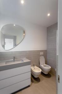 W łazience znajduje się umywalka, toaleta i lustro. w obiekcie Ilfico w mieście Cannero Riviera