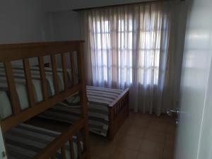 ein kleines Zimmer mit einem Kinderbett und einem Fenster in der Unterkunft Los Jazmines II in Tandil