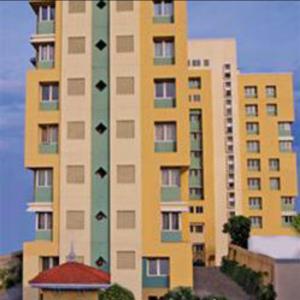 Beach Penthouse, Chennai في تشيناي: مبنى طويل أصفر وأخضر وعليه طيور