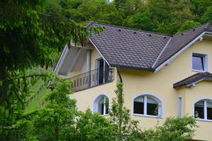a yellow house with a black roof at Villam Apartment in Maribor
