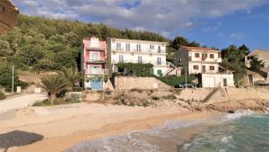 ein Haus auf einem Hügel neben dem Strand in der Unterkunft Apartmani Divić in Drvenik