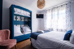 a bedroom with a blue bed and a chair at Gîte La Parenthèse 14 personnes in Loisy-sur-Marne