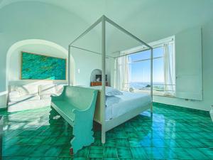 a bedroom with a bed and a large window at Il Carrubo Capri in Anacapri