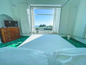a bedroom with a large bed and a window at Il Carrubo Capri in Anacapri