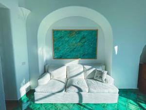 a white couch in a room with a painting at Il Carrubo Capri in Anacapri