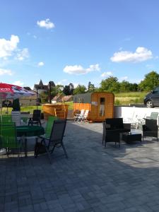 un patio con sillas y mesas y una tienda de campaña en Retro Regina en Bazna