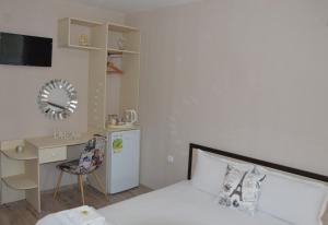 a small room with a bed and a desk and a kitchen at Villa Valentines in Kiten
