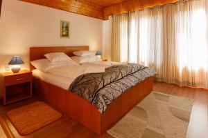 a large bed in a bedroom with a window at Central Panzió Gyula in Gyula