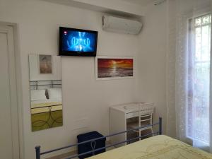 a tv on a wall in a bedroom with a bed at La Casetta in Montesilvano