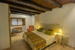Un dormitorio con una cama, una mesa y una silla. en Posada Las Espedillas, en Camaleño