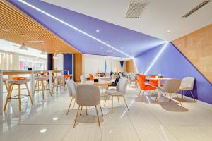 um restaurante com tecto azul, mesas e cadeiras em Holiday Inn Express Xi'an Bell Tower, an IHG Hotel em Xi'an