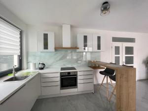 a kitchen with white cabinets and a sink and a counter at Villa Eureka in Vodice