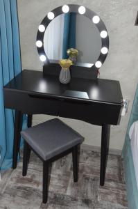 a black dressing table with a mirror and a stool at Villa Valentines in Kiten