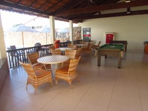 un ristorante con tavoli, sedie e tavolo da biliardo di Thanharu Praia Hotel a Anchieta