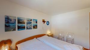 a bedroom with a bed with three pictures on the wall at Flurina 7 in Celerina