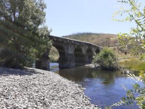 a stone bridge over a river in a field at Largo da Fonte in Sertã +35 photos