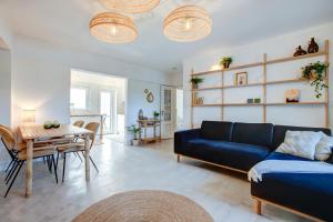 - un salon avec un canapé bleu et une table dans l'établissement Casa Golden Bamboo, private patio & 100m from the river!, à Vila Nova de Milfontes