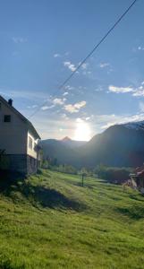 a view of a field with a house and the sunset at Dispen feriehus in Stryn