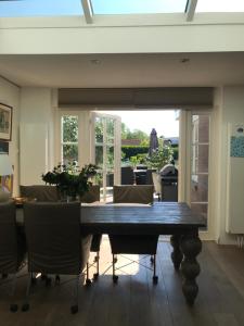 a dining room with a wooden table and chairs at Birdy in Vogelenzang