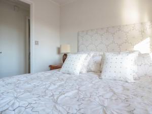 een slaapkamer met een groot wit bed met witte kussens bij Oak Lodge in Longhope