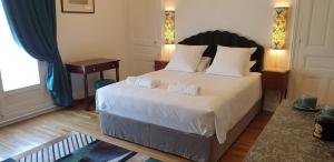 a bedroom with a large white bed with a desk at LA MAISON LEONARD in Bléré