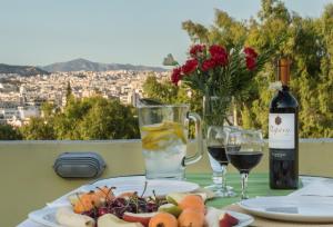 a table with a plate of food and two glasses of wine at Meros - Athenian Residencies in Athens +63 photos